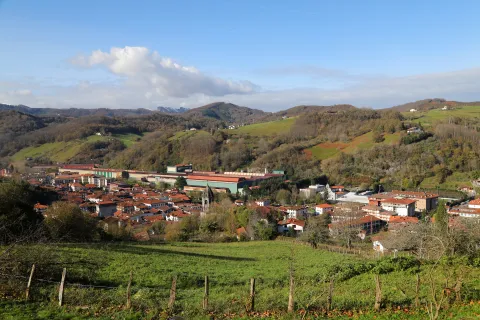Vista general del pueblo de Lesaka rodeado de montes boscosos y prados verdes.