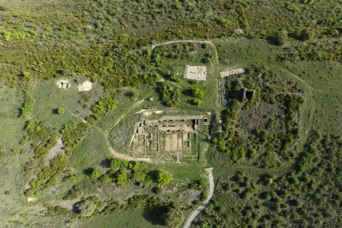 Vista aerea de las ruinas de Santa Criz de Eslava rodeadas de arboles y vegetacion, sendero y construcciones anexas.