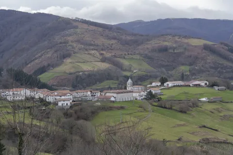 Vista panorámica aérea del valle de Saldias con el pueblo rodeado de montañas verdes y espacios de cultivo.