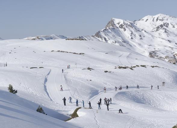 Esquiadores en Larra-Belagua bajo montañas nevadas del Pirineo navarro.