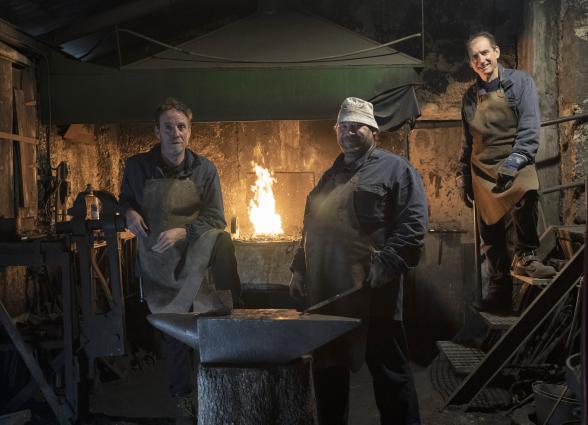 Herrería tradicional en Atrevete a Forjar con maestros profesionales junto a horno de forja encendido y yunque de hierro.