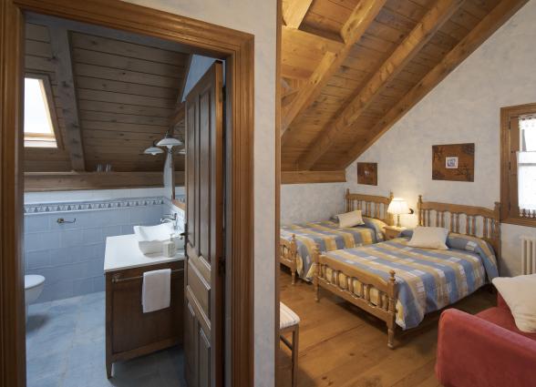 e madera, dos camas de madera y baño en alojamiento rural en Isaba, Pirineo de Navarra.