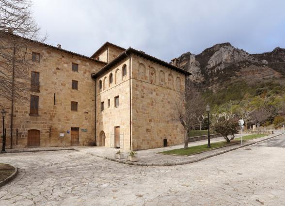 Monasterio de Leyre con arquitectura romanica de piedra, plaza empedrada y acantilados rocosos al fondo en Sangüesa.