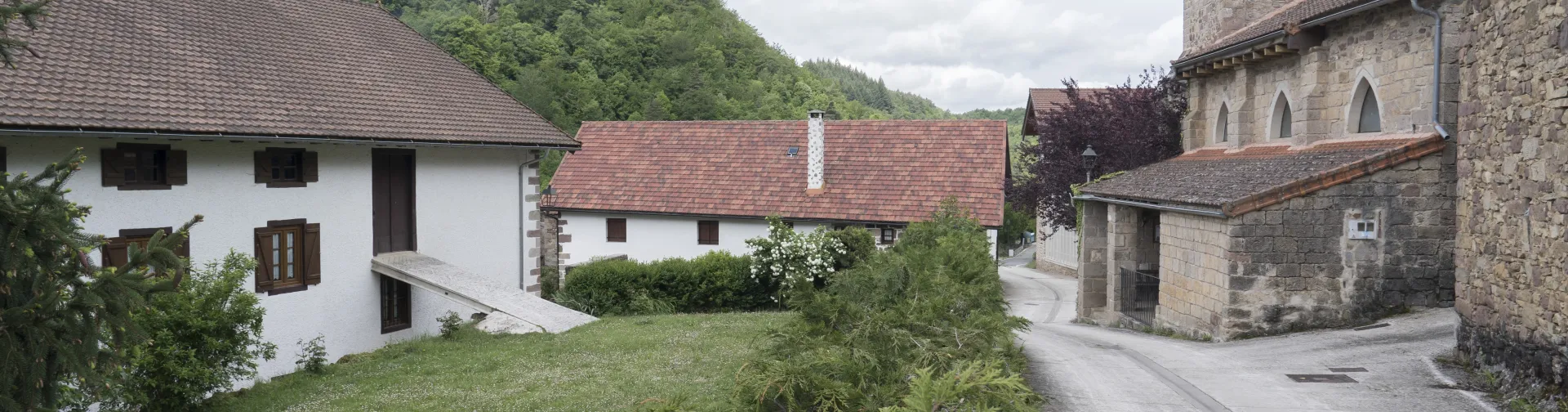 Valle pirenaico con vista de Azparren, caseríos tradicionales navarros rodeados de montañas.