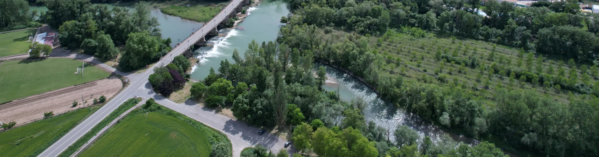 Casedako airetiko bista, Aragoi ibaia, zelai berdeak eta baso mendiak dituena.