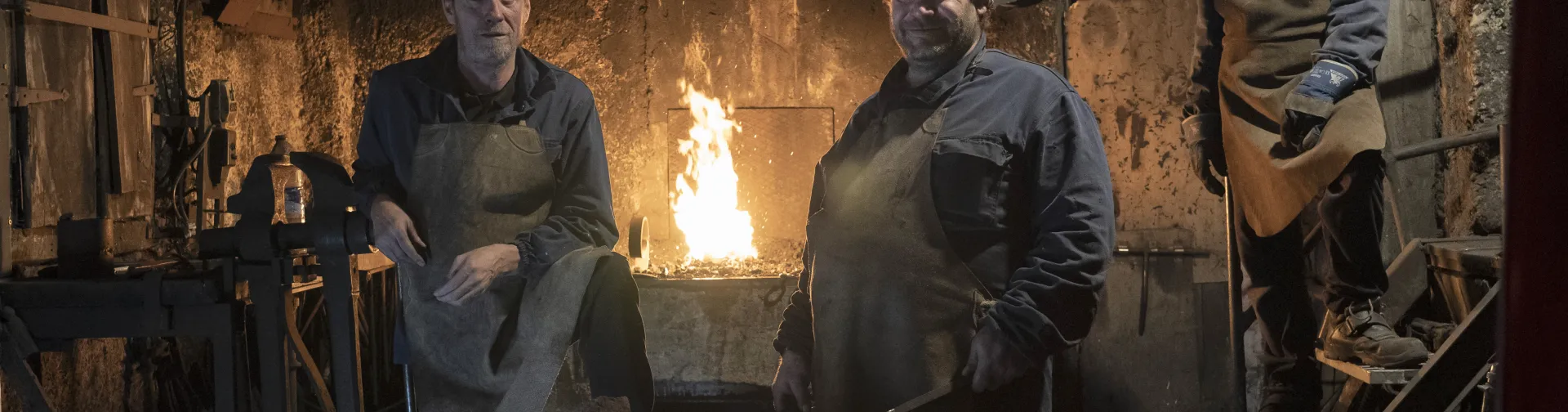Herrería tradicional en Atrevete a Forjar con maestros profesionales junto a horno de forja encendido y yunque de hierro.