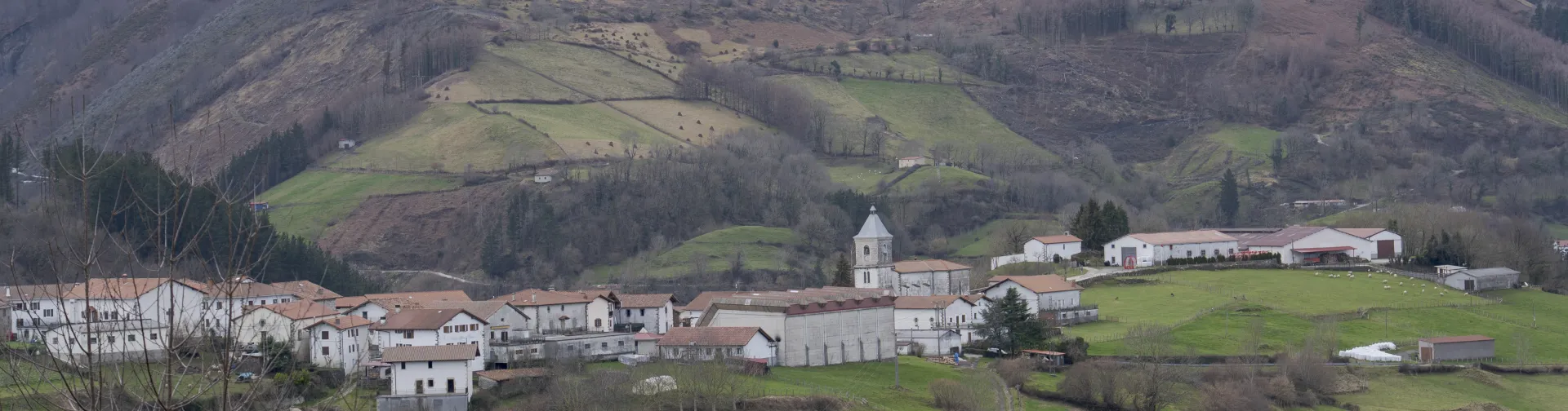 Vista panorámica aérea del valle de Saldias con el pueblo rodeado de montañas verdes y espacios de cultivo.