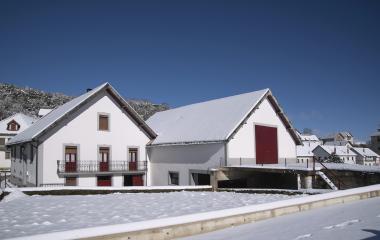 Conjunto de casas en el pueblo de Abaurrea Alta cubierto de nieve con arquitectura tradicional pirenaica