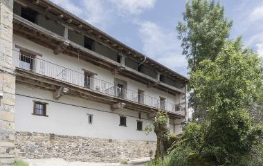 Caserio tradicional de piedra y madera en Agorreta con balconadas de hierro forjado y vigas de madera vista.