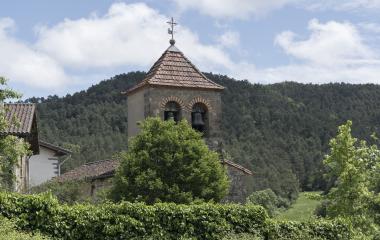 Campanario de iglesia de Agorreta, rodeada de bosque pirenaico.