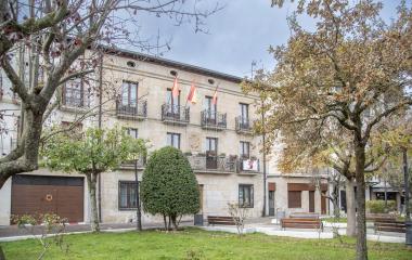 Fachada del ayuntamiento de Alsasua con escudo heráldico en la plaza principal y rodeado de jardines