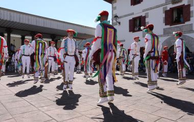 Danzaris de Bolantes en indumentaria tradicional blanca con cintas multicolores en la plaza del Luzaide.