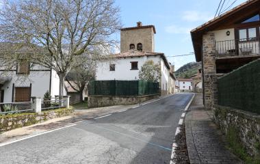 Calle de Guesa con iglesia de piedra y campanario y casas tradicionales