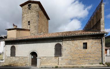 Iglesia de piedra con campanario y torre cuadrada en Guesa, arquitectura religiosa tradicional pirenaica.