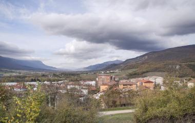 Vista panorámica de Irurtzun, edificios residenciales y montañas al fondo bajo cielo nublado.