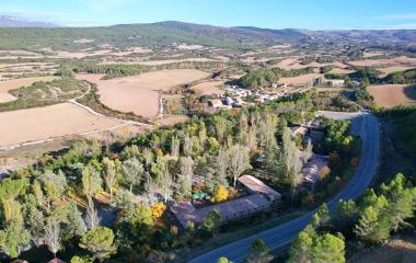 Vista aérea del pueblo de Javier con carretera y prados y bosque.