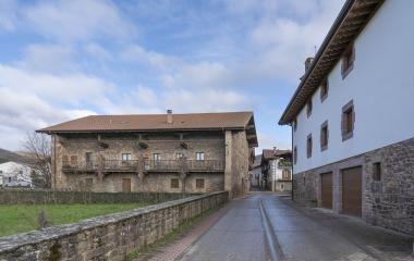 Calle de Lantz con casas de piedra de arquitectura tradicional y cielo parcialmente nublado.