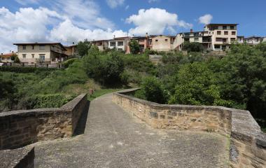 Vista desde el puente de piedra en Lumbier, con pueblo de arquitectura tradicional al fondo.