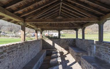Estructura de piedra histórica con cubierta, posiblemente molino o edificio tradicional.
