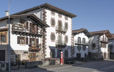 Casa solariega con balcones de madera roja y galerías en Narbarte.