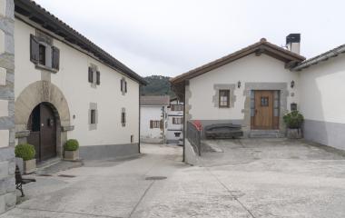 Casas tradicionales blancas en Orondritz, con calle que conecta al pueblo.
