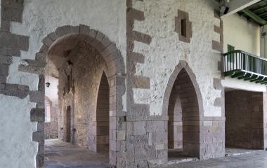 Vista de dentro del frontón con un arco y una puerta que une la iglesia San Andrés y el frontón en Azpilikueta.