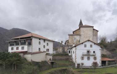 Vista de atrás de un par de casas y de la iglesia de Ezkurra.