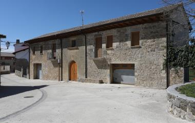 Edificio de piedra de construcción tradicional en Romanzado con puerta arqueada.