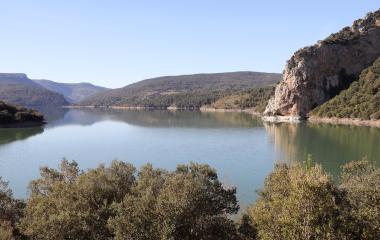 Embalse de Itoitz rodeado de bosque con cortados calizos y aguas tranquilas en el Pirineo de Navarra.