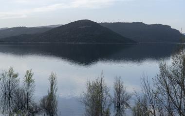 Embalse de Itoitz rodeado de bosque denso de hayas y abetos con aguas tranquilas reflejando la montaña.
