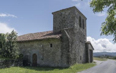 Iglesia de piedra con torre campanario cuadrada al lado de la carretera en Usetxi, Pirineo navarro.