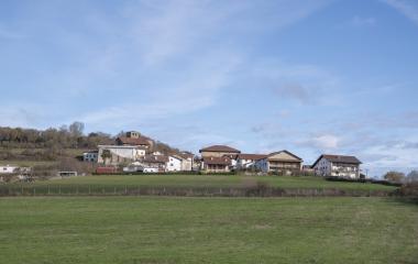 Pueblo de Atez con casas de piedra, rodeado de vegetación natural y prados verdes.