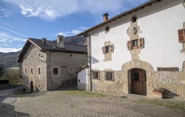 Casas de piedra tradicionales en Imoz, plaza empedrada con montañas al fondo.