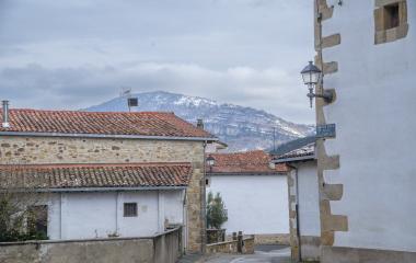 Conjunto de casas de piedra blancas en Ziordia con montañas nevadas de fondo.