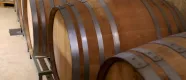 Barriles de madera con aros metalicos en Bodega Eslava, destinados a la elaboracion y envejecimiento de vino.