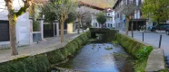 Rio atraviesa el pueblo de Lesaka con casas de piedra y torre a los lados.